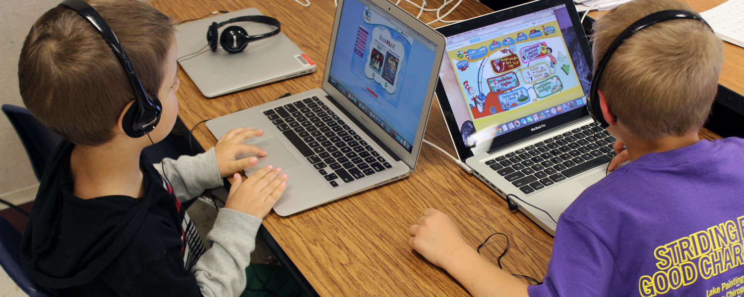 fourth grade students playing on computers