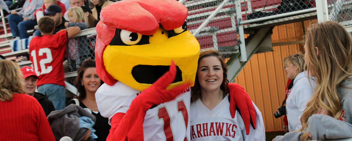 Student at football game with the warhawk mascot 