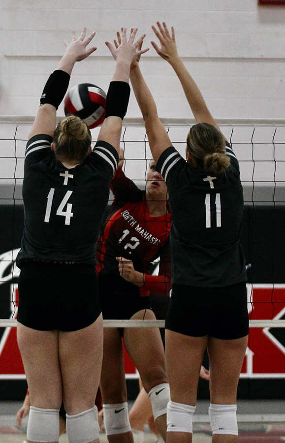 North Mahaska girl's volleyball team spiking the ball at the opposing team members