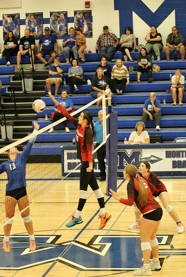 North Mahaska girls volleyball players blocking a shot from the opposing team.